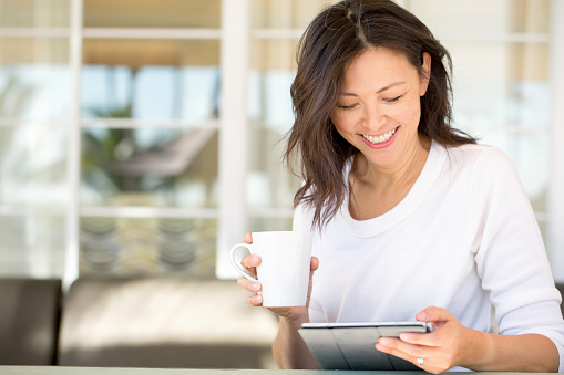 Portrait of an Asian woman laughing and smiling.