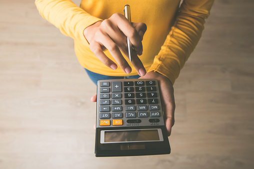 woman-using-a-calculator-with-a-pen-in-her-hand.