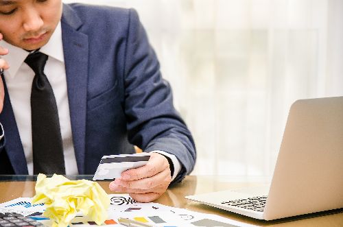 Guy worried while looking at his credit card