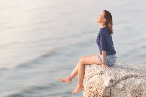 Girl sitting on a cliff happy