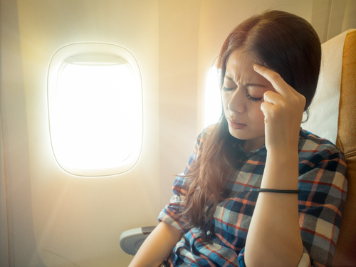 woman in airplane headache 