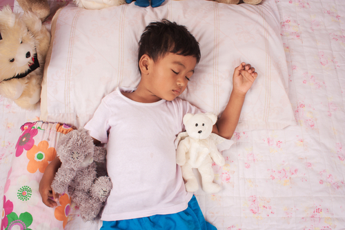 boy sleeps with teddy bears