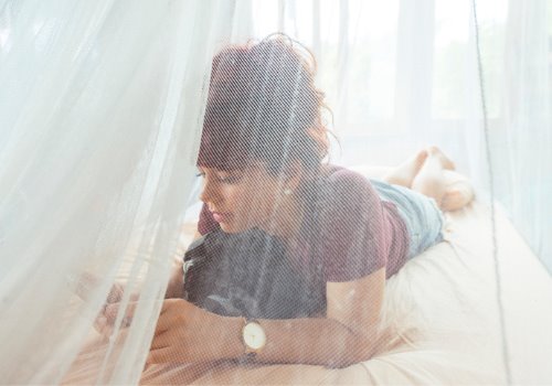 woman-mobile-phone-bed-curtains-aia-malaysia.jpg