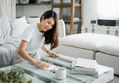 woman-tidying-up-the-living-space-and-wiping-the-coffee-aia-malaysia