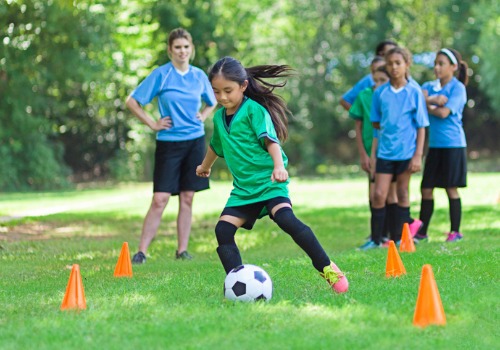 elementary-age-soccer-female-athlete-kicks-ball-around-cones-aia-malaysia