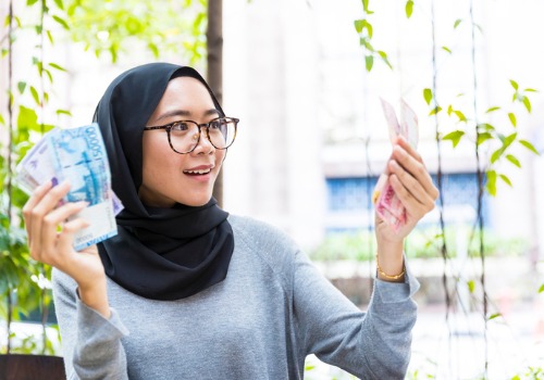 girl-holding-paper-currency-joyfully-aia-malaysia