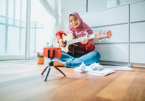 young-asian-girl-writing-music-and-playing-guitar-while-online-streaming-picture-aia-malaysia