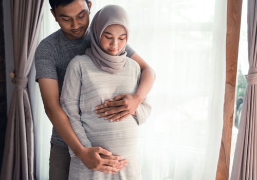 husband hugging pregnant wife